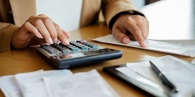 Woman uses calculator to prepare her 2021 tax returns